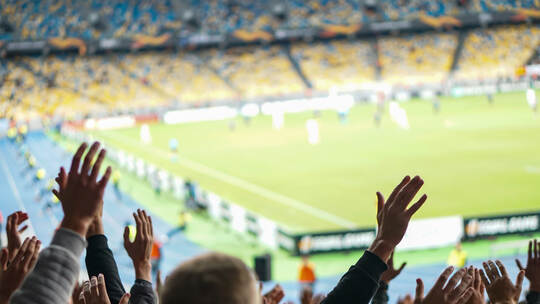 Football- soccer fans support their team and celebrate goal in full stadium with open air.